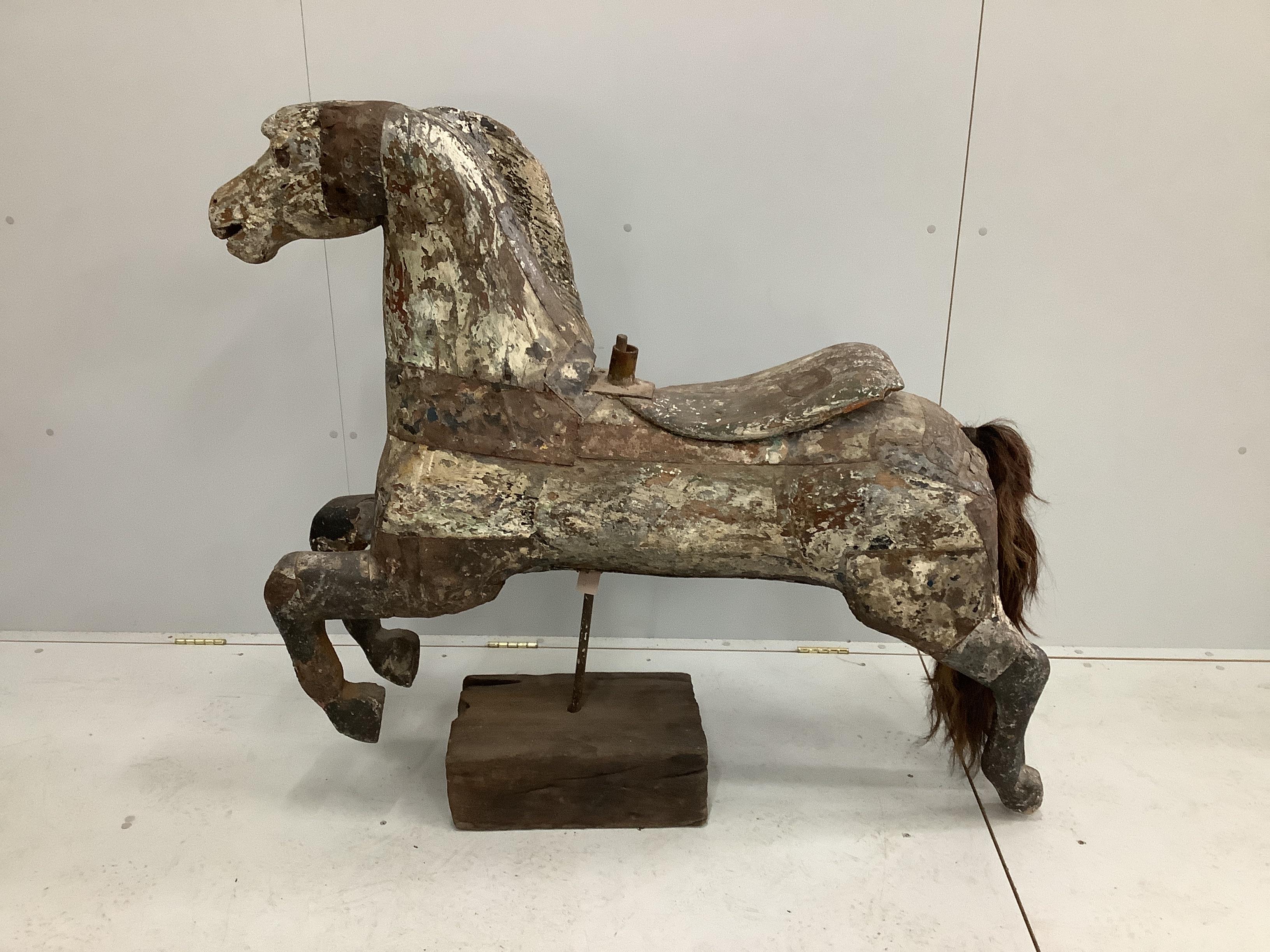 A vintage metal bound carved wood carousel fairground horse with traces of original paint, length 128cm, height 118cm